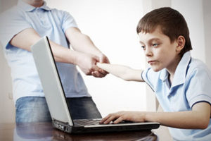 Father dragging son from the computer